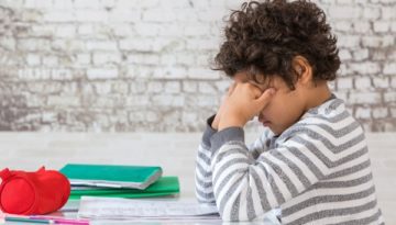 unhappy child with head in his hands